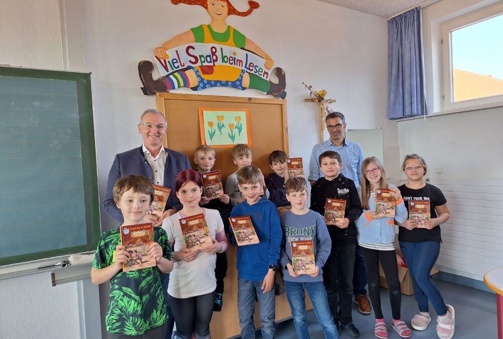 MdL Hauber übergibt zum „Welttag des Buches“ Band 4 der „Isar-Detektive“ an die Grundschule Pleinfeld