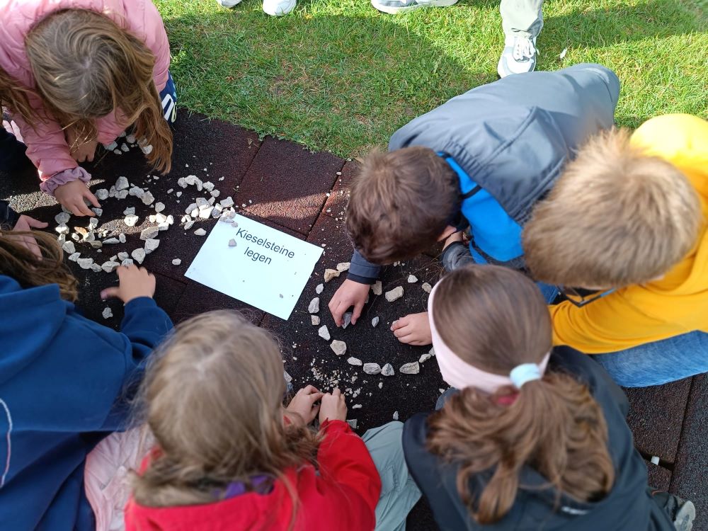 Schülerinnen und Schüler der Realschule Hensoltshöhe beim kreativen Legen von Kieselsteinen
